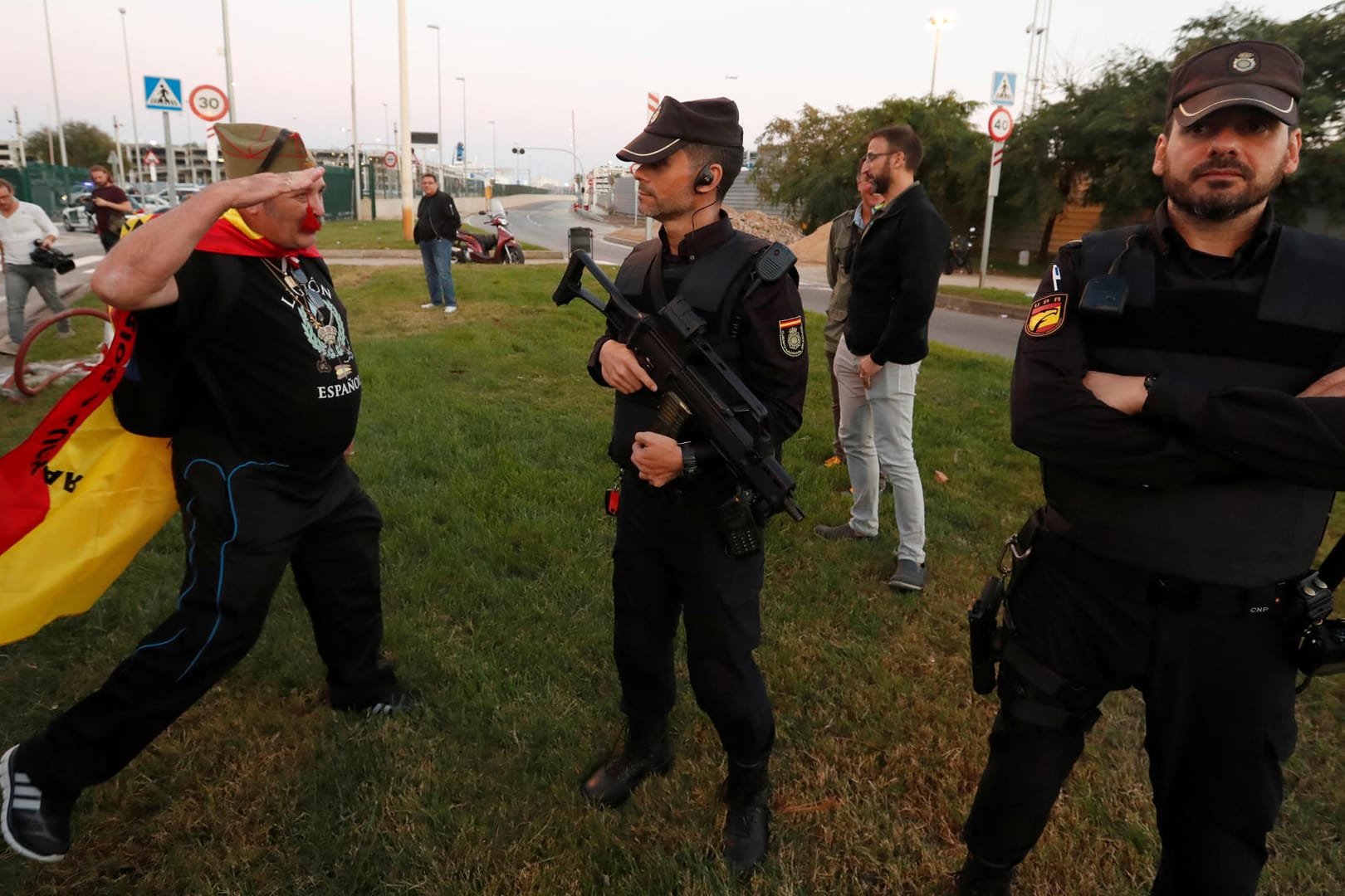 Ein Befürworter der spanischen Einheit salutiert vor spanischen Polizisten.