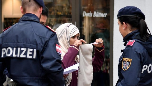 Sie müssen es durchsetzen: Eine Polizeistreife spricht in Zell am See mit einer Muslimin. Sie müssen es durchsetzen: Eine Polizeistreife spricht in Zell am See mit einer Muslimin.