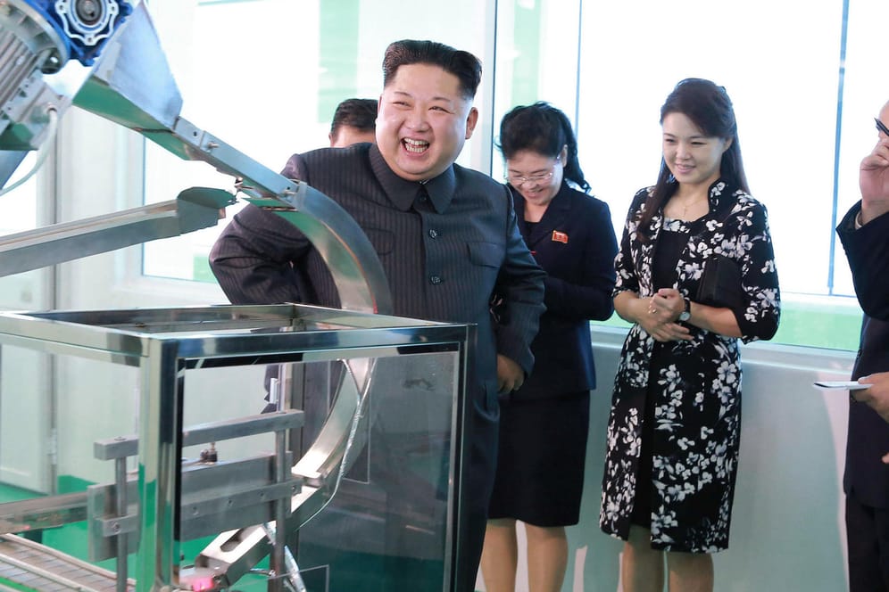 Kim Jong Un und seine Frau Ri Sol Ju betrachten die Herstellung der Produkte.