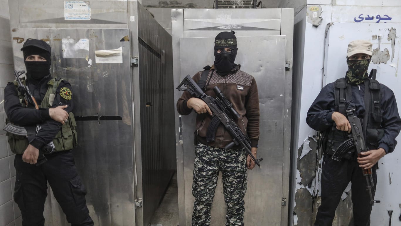 Kämpfer der militanten Organisation Islamischer Dschihad bewachen in Deir al-Balah die Leichen getöteter Kameraden