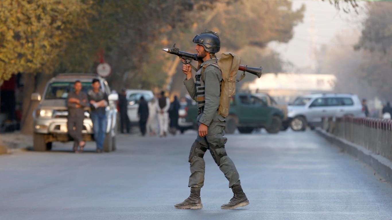 Ein afghanischer Polizist kontrolliert eine Straße in der Nähe des Anschlagsortes.