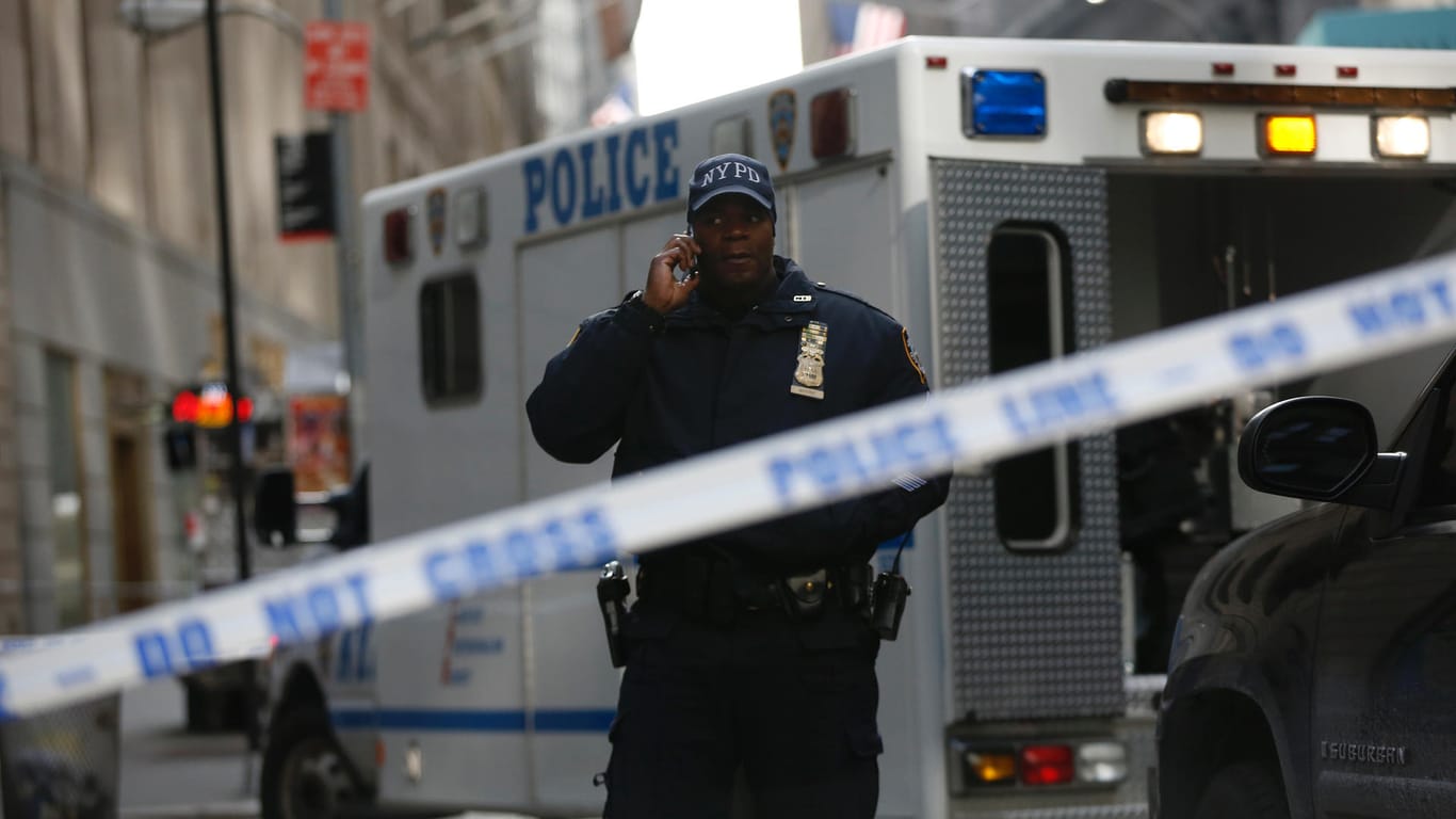 Ein New Yorker Polizist steht im Zentrum der Stadt vor einem Einsatzfahrzeug (Archivbild).