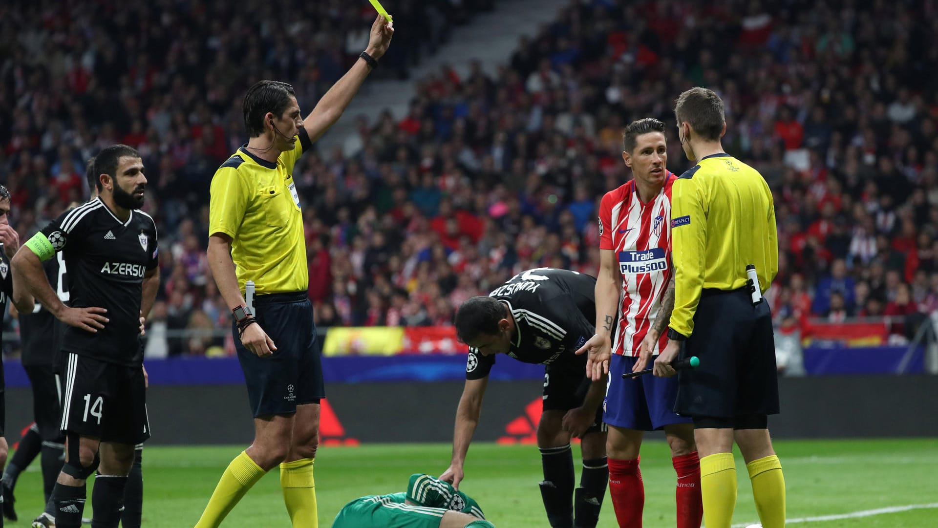 Madrids Fernando Torres (2. v. r.) bekommt vom deutschen Schiedsrichter Deniz Aytekin die Gelbe Karte.