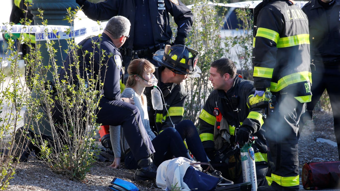 Einsatzkräfte versorgen eine Frau, die auf einem Fahrradweg von dem Angreifer umgefahren wurde.