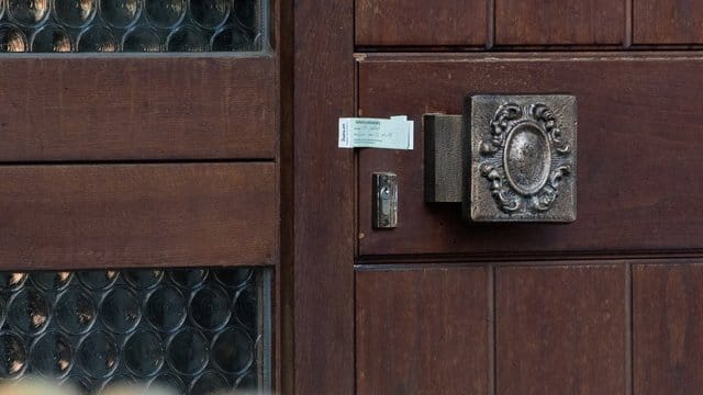 Ein Verschlusssiegel der Polizei ist an der Eingangstür des Einfamilienhauses angebracht. Ein Verschlusssiegel der Polizei ist an der Eingangstür des Einfamilienhauses angebracht.