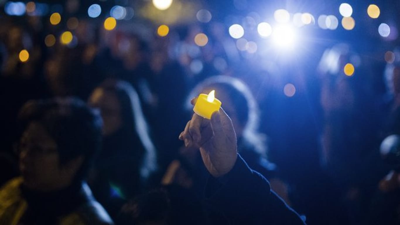 Eine LED-Kerze wird während einer Nachtwache zum Gedenken der Opfer des Anschlags hochgehalten.