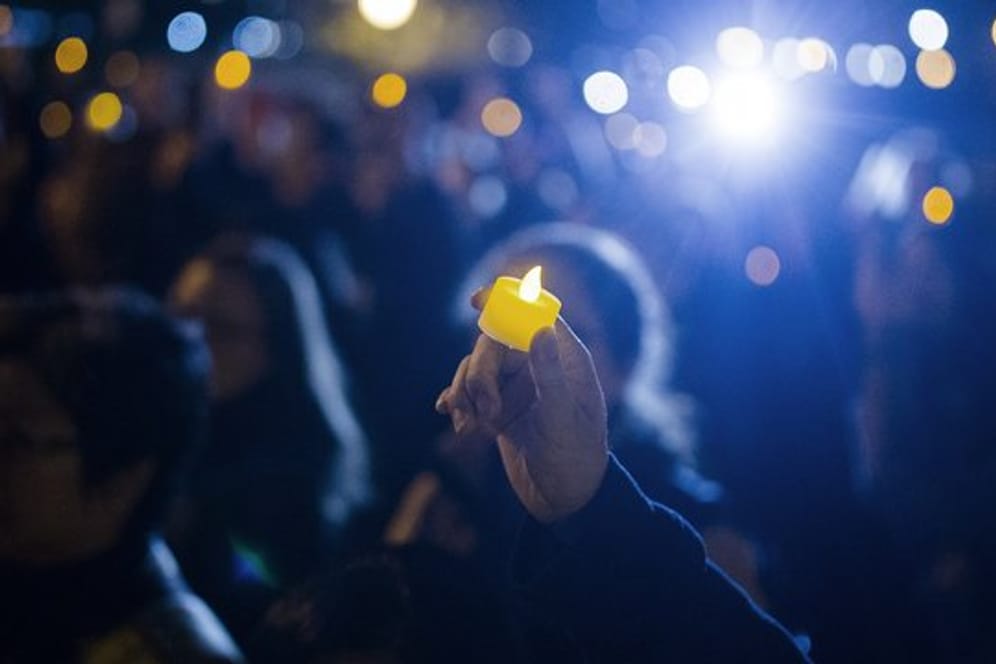 Eine LED-Kerze wird während einer Nachtwache zum Gedenken der Opfer des Anschlags hochgehalten.