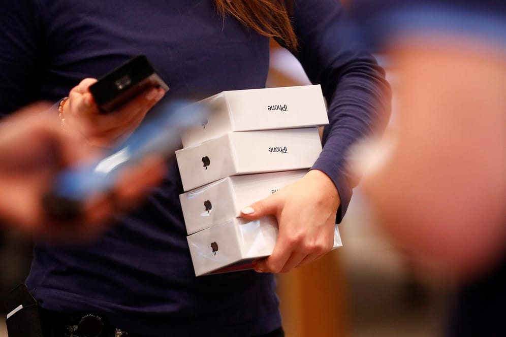 Eine Mitarbeiterin im Berliner Apple-Store trägt mehrere iPhone X-Verpackungen unterm Arm