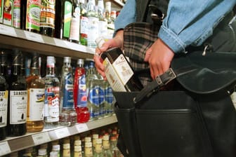 Ladendiebin beim Diebstahl einer Flasche Alkohol im Supermarkt
