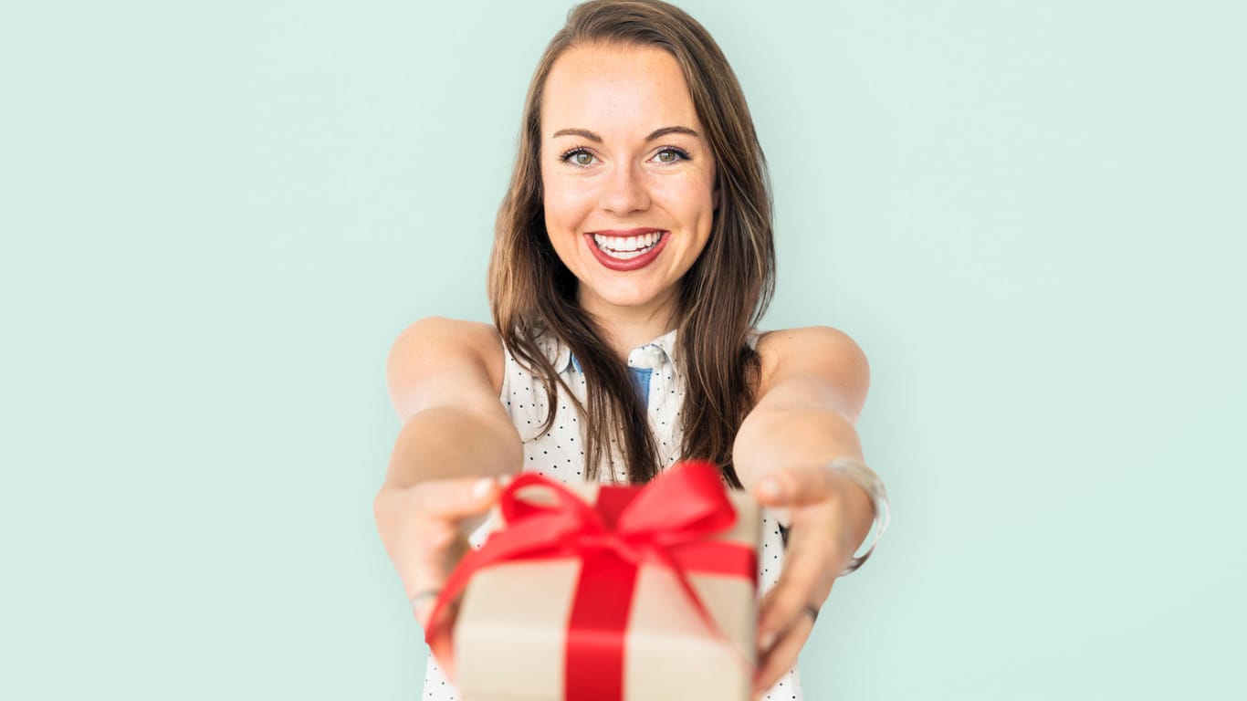 Lächelnde Frau überreicht ein Geschenk
