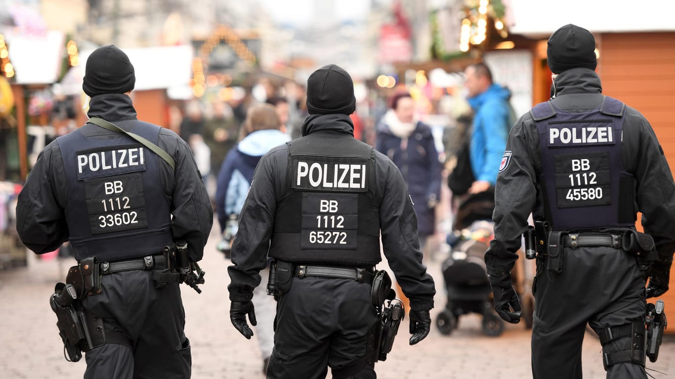 Polizisten mit schusssicheren Westen patrouillieren auf dem Weihnachtsmarkt in Potsdam.
