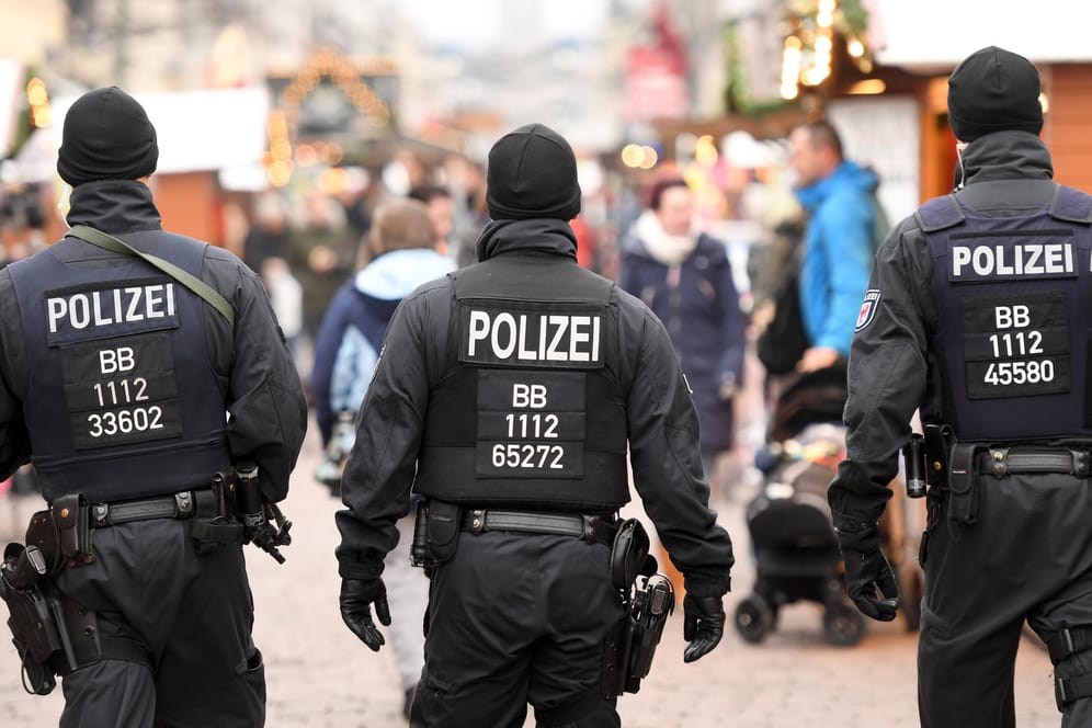 Polizisten mit schusssicheren Westen patrouillieren auf dem Weihnachtsmarkt in Potsdam.