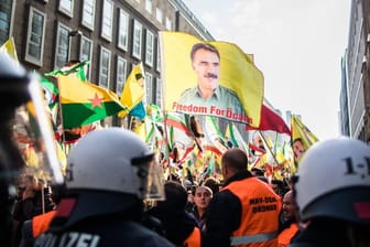 Polizisten blockieren eine Kurden-Demonstration in Düsseldorf, bei der verbotene Fahnen von Öcalan geschwenkt werden.