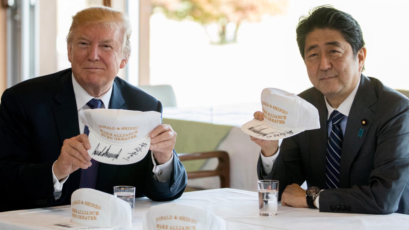 Donald Trump und Japans Ministerpräsident signieren Baseball-Kappen mit der Aufschrift "Donald and Shinzo, Make Alliance Even Greater" ("Donald und Shinzo machen die Allianz noch großartiger").