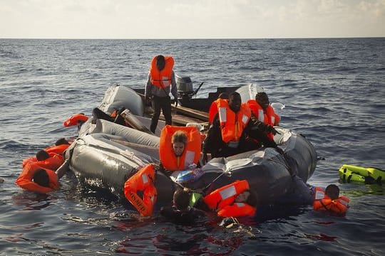 Flüchlinge treiben im Mittelmeer, bevor sie von Teams von SOS Mediterranée und Ärzte ohne Grenzen auf das Rettungsschiff "Aquarius" gerettet wurden.