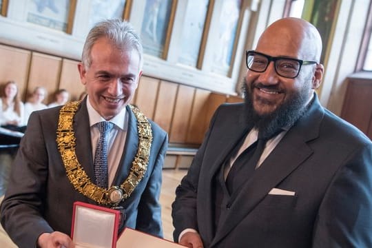 Oberbürgermeister Peter Feldmann überreicht Moses Pelham die Goetheplakette.