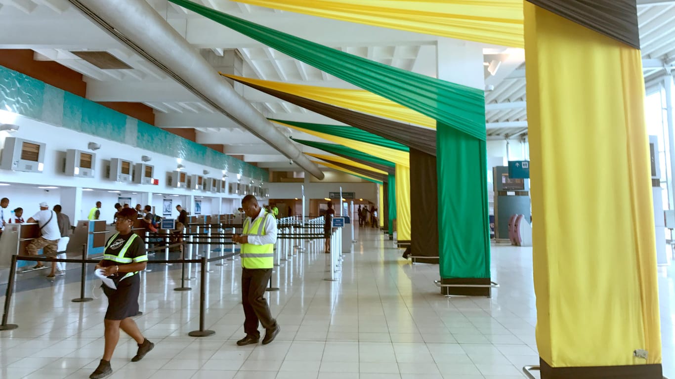 Große schwarz-gelb-grüne Stoffbahnen schmücken den Check-In-Bereich im Flughafen von Kingston.