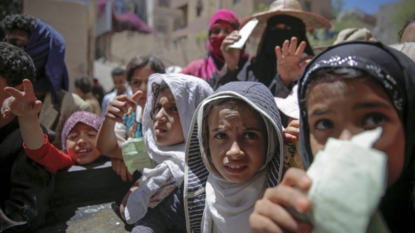 Einwohner von Sanaa warten von einer lokalen Wohltätigkeitsorganisation auf eine Essensration.