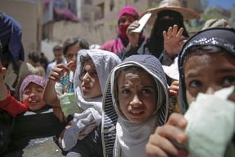 Einwohner von Sanaa warten von einer lokalen Wohltätigkeitsorganisation auf eine Essensration.