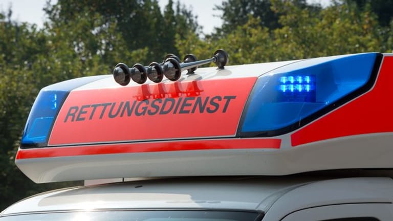 Blaulicht leuchtet auf dem Dach eines Krankenwagens: In Oberbayern ist ein Mann von einem Hang abgestürzt und gestorben.