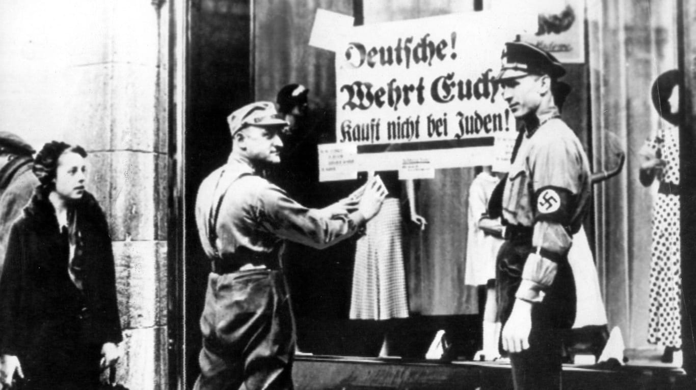 9. November 1938: SA-Männer vor einem jüdischen Geschäft. Und das Volk steht stumm dabei.