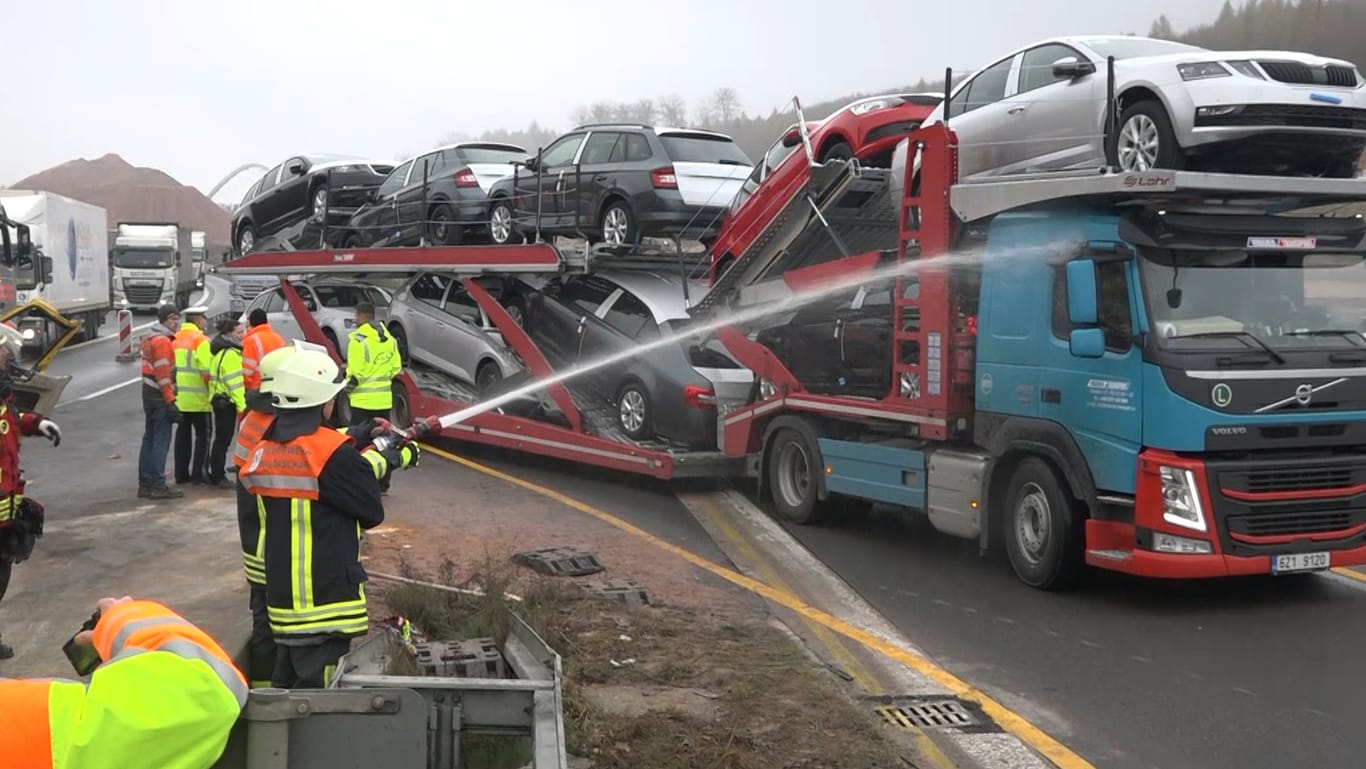 Nach Unfall mit drei Toten: Feuerwehr spritzt Lkws und Fahrzeuge, deren Fahrer den Unfallort mit ihren Handys filmten.