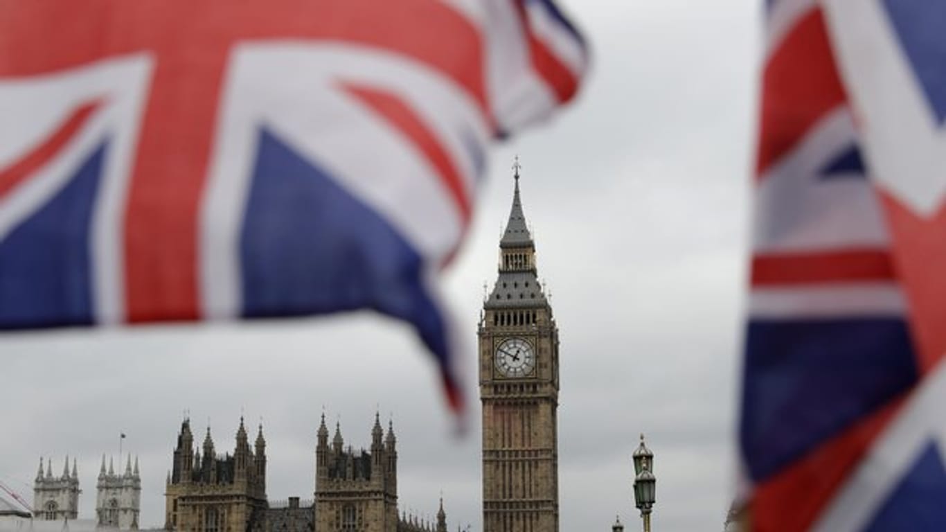 Britische Fähnchen an einem Touristen-Geschäft wehen vor den Houses of Parliament in London.