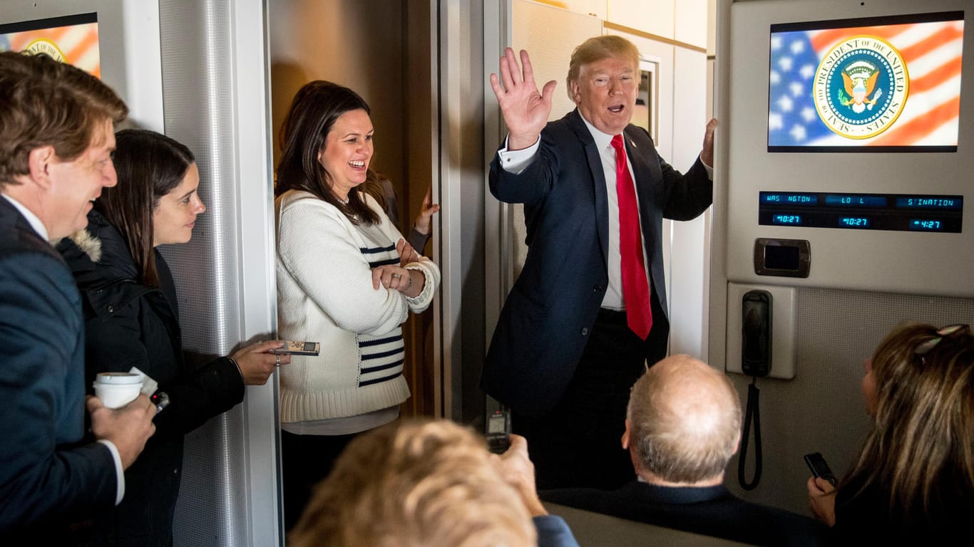Donald Trump und seine Sprecherin Sarah Huckabee Sanders (links) unterhalten sich an Bord der "Air Force One" mit Journalisten.