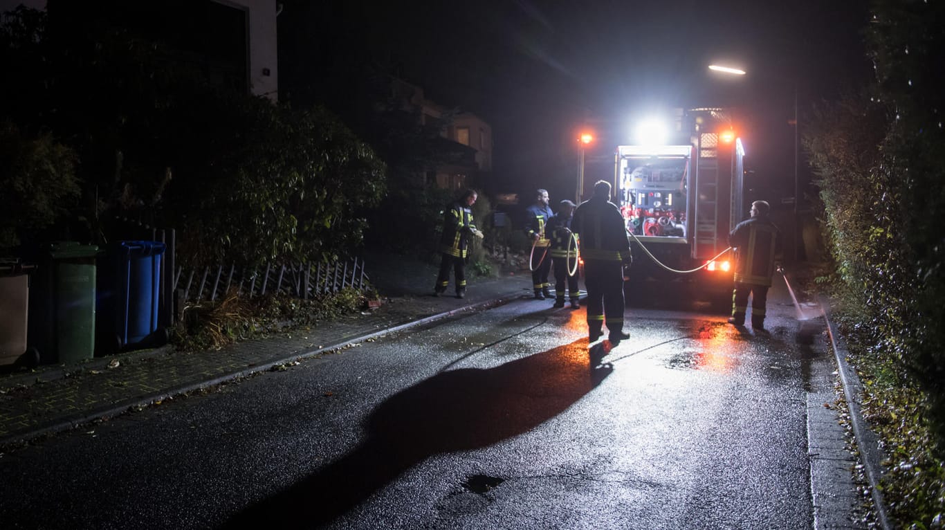 Am Samstagabend werden die letzten Spuren der Bluttat in Wilnsdorf beseitigt – Einsatzkräfte der Feuerwehr säubern die Straße.