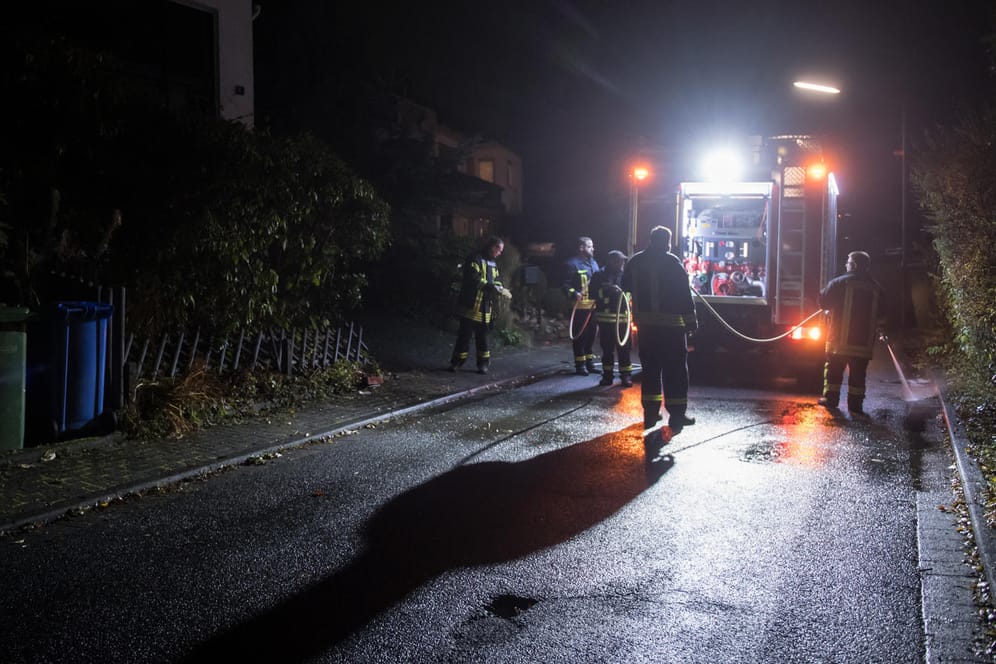 Am Samstagabend werden die letzten Spuren der Bluttat in Wilnsdorf beseitigt – Einsatzkräfte der Feuerwehr säubern die Straße.