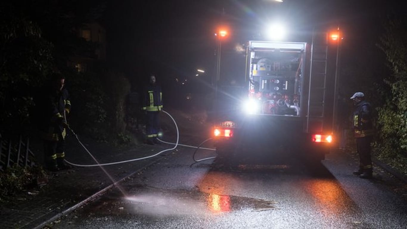 Familientragödie in Wilnsdorf: Feuerwehrmänner reinigen die Straße in der Nähe des Tatorts.