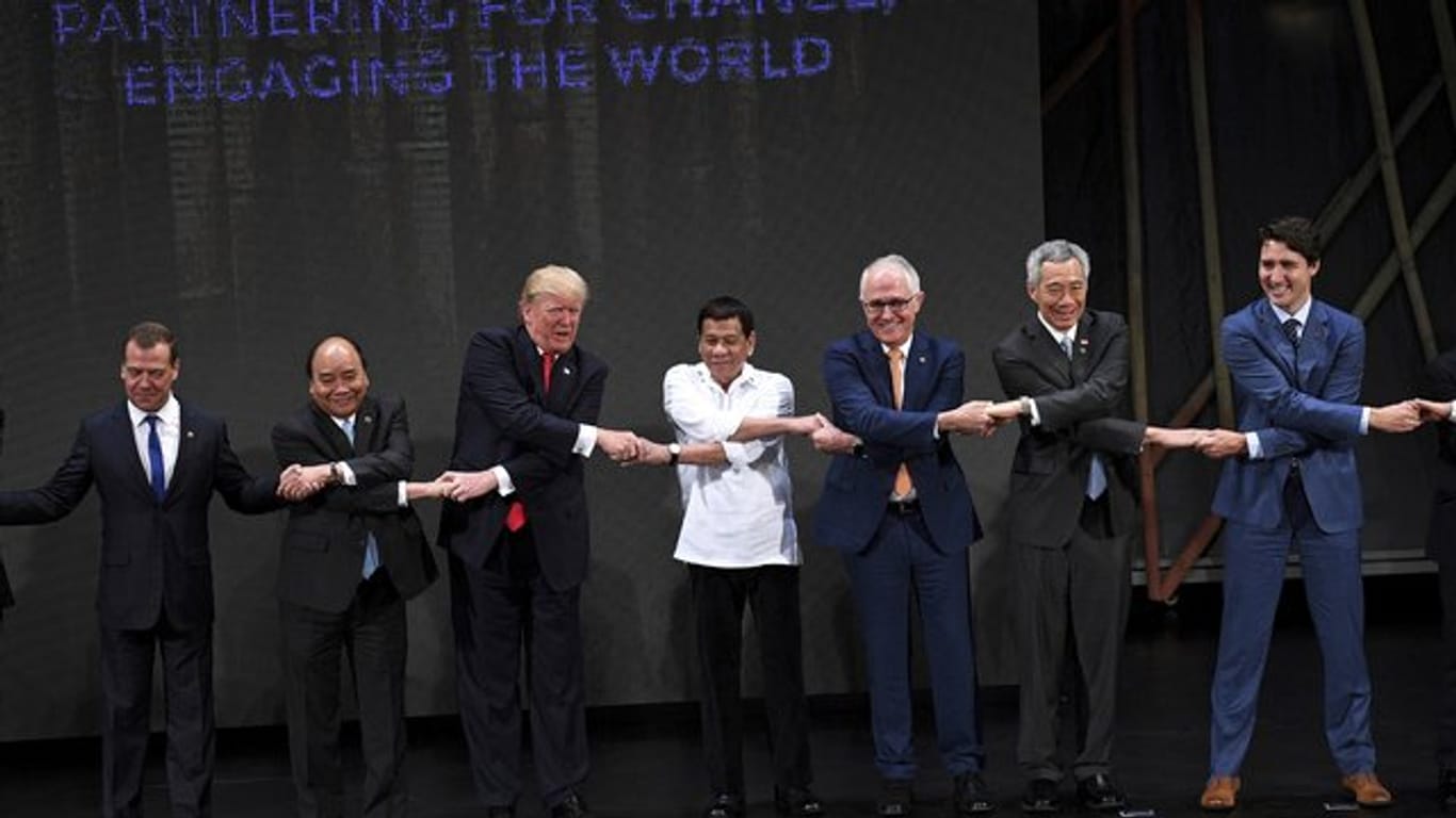 Die Teilnehmer des Asean-Gipfels stehen während der Eröffnungszeremonie Hand in Hand nebeneinander.