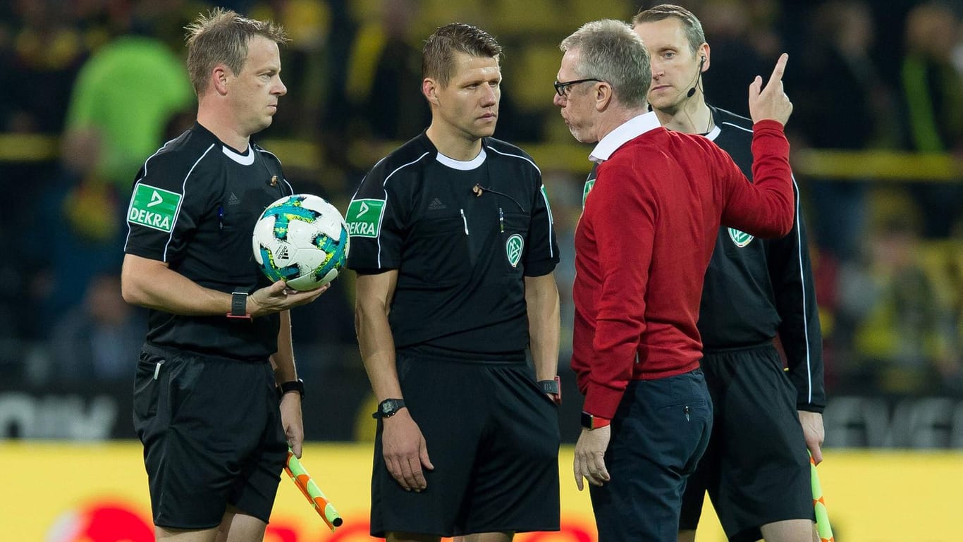 Peter Stöger (in rot) diskutierte mit Schiedsrichter Patrick Ittrich nach dem Spiel in Dortmund.