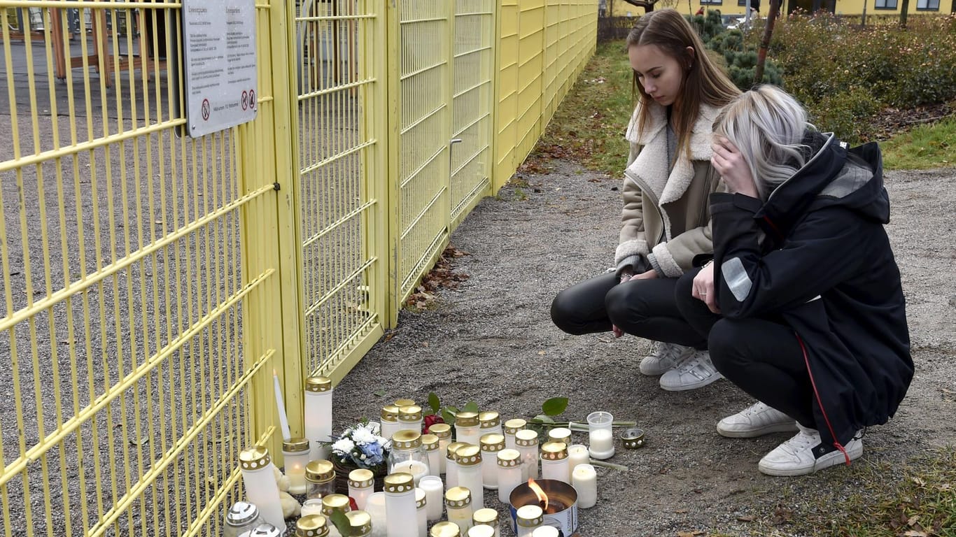 Zwei Mädchen trauern am Tatort um das getötete Kind.