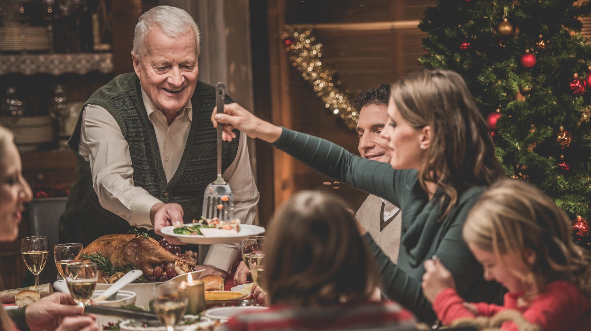 Eine Familie beim Weihnachtsessen: Was wird bei den Deutschen zu Weihnachten aufgetischt?