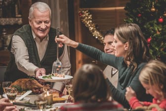 Eine Familie beim Weihnachtsessen: Was wird bei den Deutschen zu Weihnachten aufgetischt?