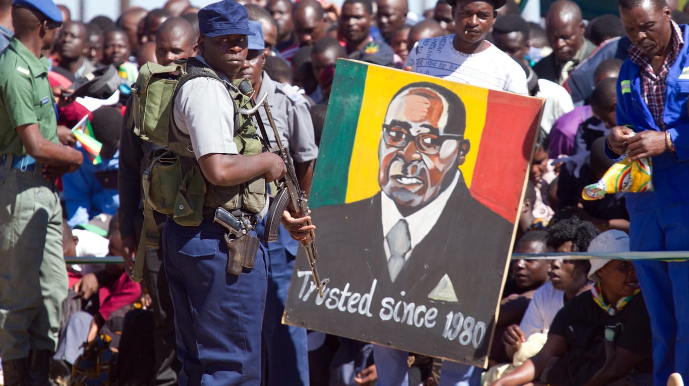 Bewaffneter Polizist vor einem Porträt von Robert Mugabe (Archivbild): Machtkampf um die Nachfolge des Diktators