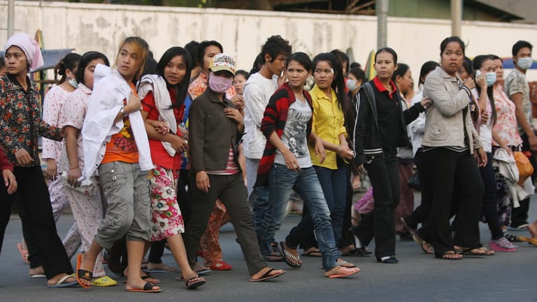 Passanten an einer Straße in Phnom Penh, Kambodscha.