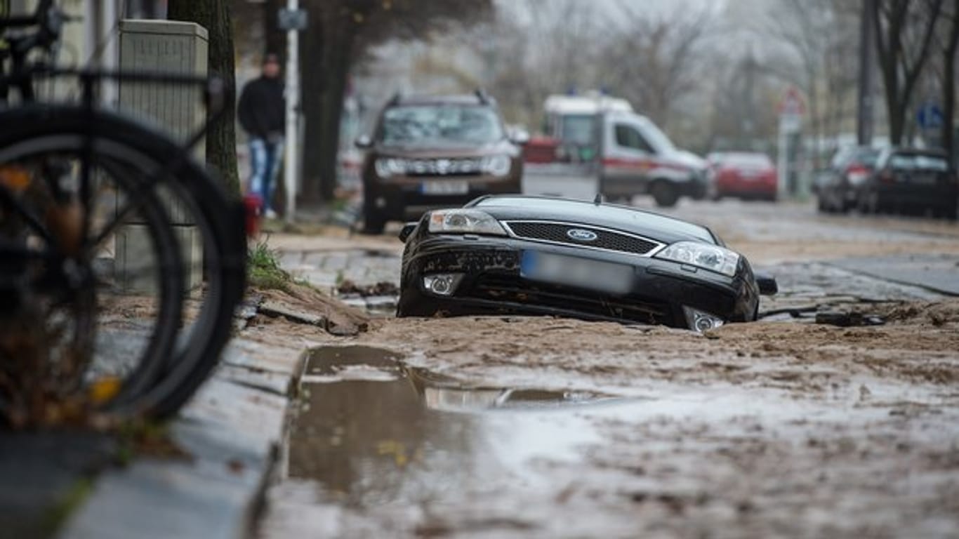 Nach dem Wasserrohrbruch in Berlin-Lichtenberg ist eine Straße abgesackt und hat ein Auto zur Hälfte in die Tiefe gerissen.