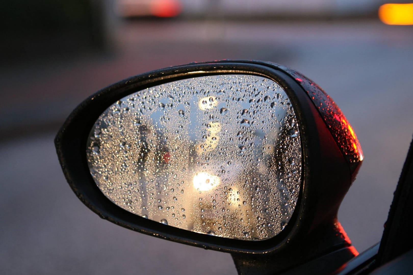 Blick in den Rückspiegel eines Autos bei Regen: Der Licht-Test hat gravierende Mängel an vielen Fahrzeugen festgestellt.