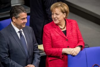 Bundeskanzlerin Angela Merkel und Außenminister Sigmar Gabriel unterhalten sich im Bundestag in Berlin.