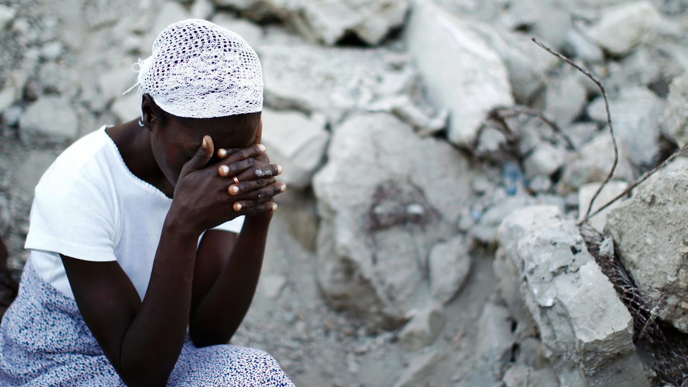 Eine Frau betet vor den Trümmern der Kathedrale in Port-au-Prince: Das schwere Erdbeben 2010 kostete 200.000 menschen das Leben.