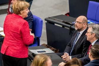 Bundeskanzlerin Angela Merkel spricht mit Martin Schulz, dem SPD-Bundesvorsitzenden im Bundestag in Berlin.