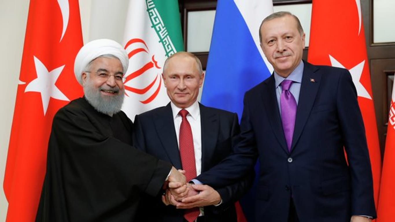 Russlands Präsident Wladimir Putin hat in Sotschi den iranischen Präsidenten Hassan Ruhani (l) und den türkischen Präsidenten Recep Tayyip Erdogan (r) empfangen.