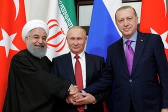 Russlands Präsident Wladimir Putin hat in Sotschi den iranischen Präsidenten Hassan Ruhani (l) und den türkischen Präsidenten Recep Tayyip Erdogan (r) empfangen.