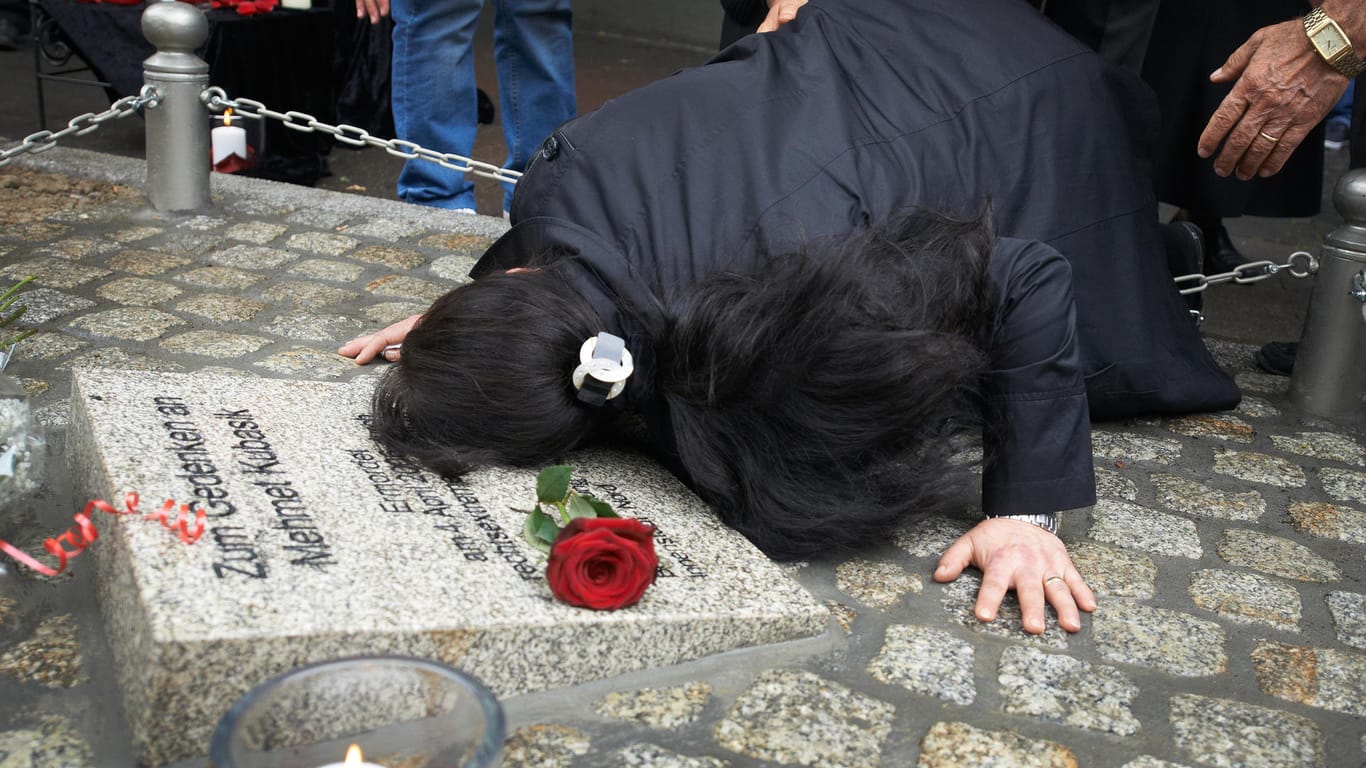 Die Witwe des 2006 von der rechtsextremen Terrorzelle NSU ermordeten Mehmet Kubasik liegt weinend auf einem Gedenkstein für ihren Ehemann.