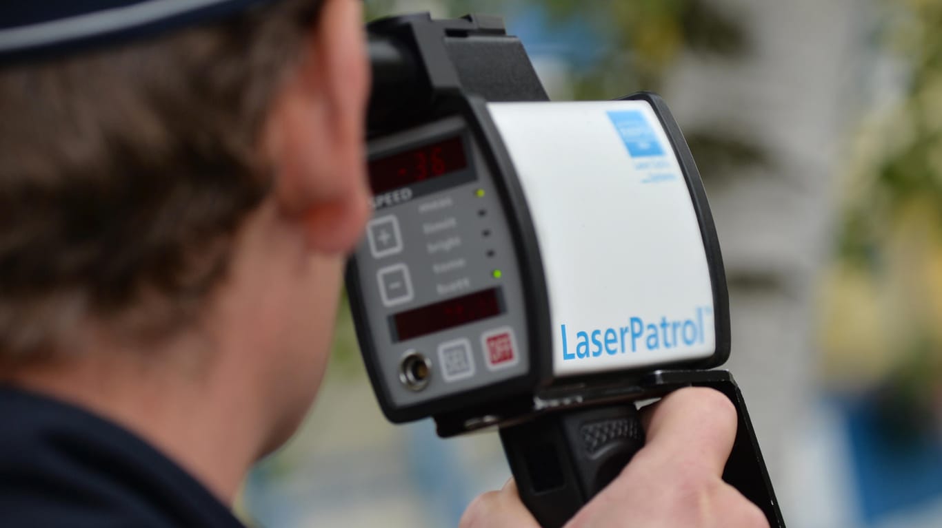 Polizist misst Geschwindigkeit mit einem Lasermessgerät