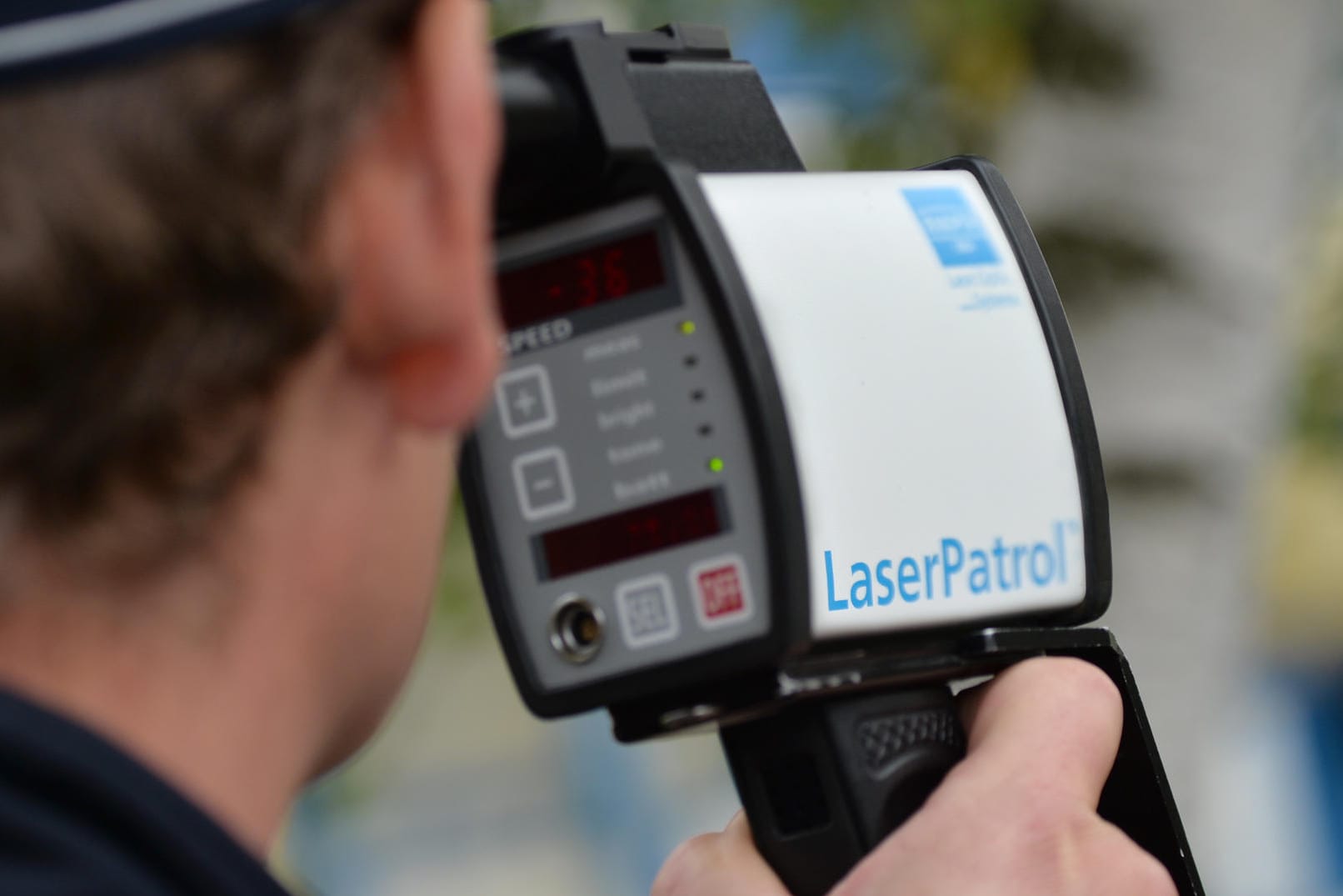 Polizist misst Geschwindigkeit mit einem Lasermessgerät
