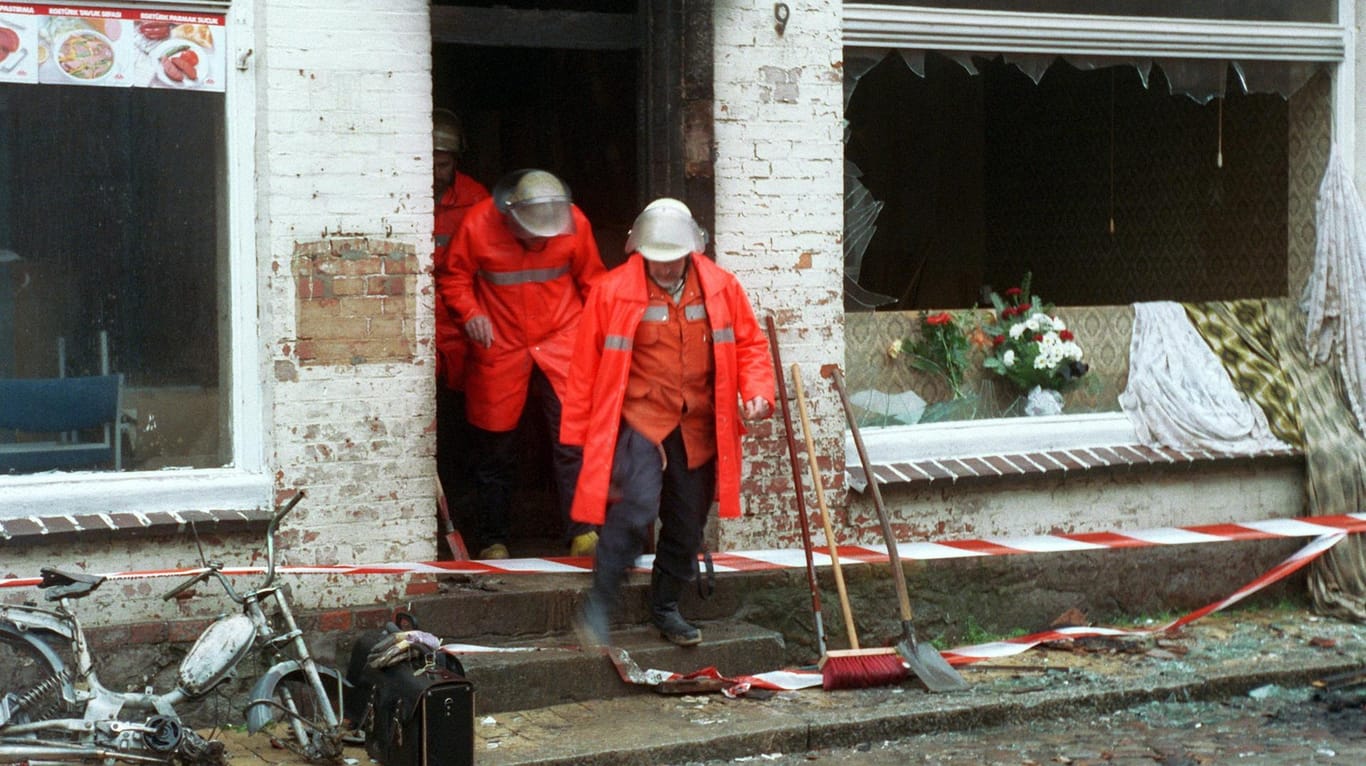 Feuerwehrmänner verlassen am 23.11.1992 das völlig zerstörte Haus: Die Brandanschläge von Mölln sorgten weltweit für Erschütterung. Bei einer rassistisch motivierten Tat kamen Menschen ums Leben.