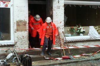 Feuerwehrmänner verlassen am 23.11.1992 das völlig zerstörte Haus: Die Brandanschläge von Mölln sorgten weltweit für Erschütterung. Bei einer rassistisch motivierten Tat kamen Menschen ums Leben.